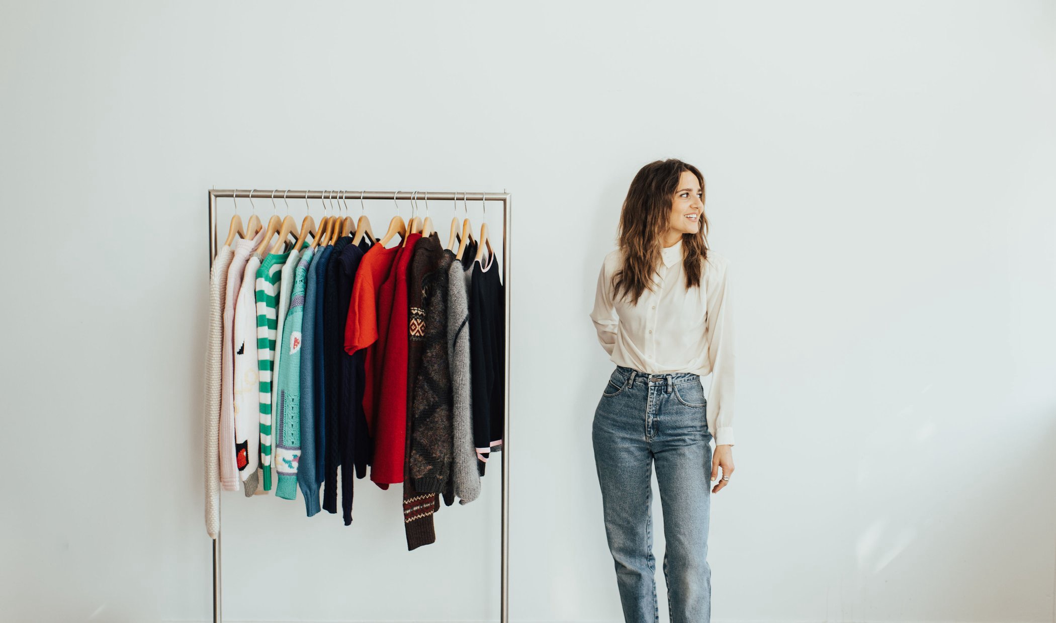 Rad Dolo, personal stylist, standing beside a rack of clothes in her Minneapolis studio